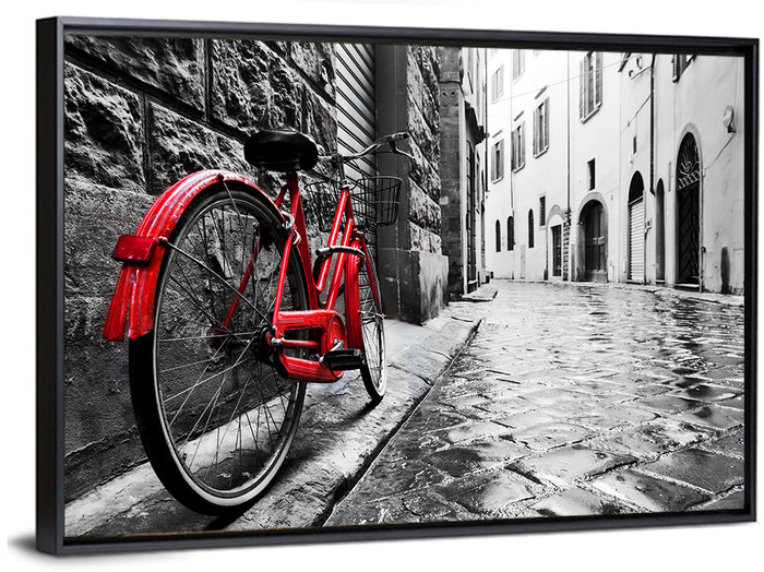Red Bicycle on Rainy Cobblestone Street Wall Art as a framed canvas