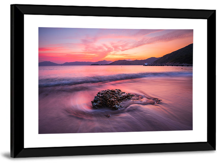 Pink Sunset Over Rock and Pier Wall Art as a framed print