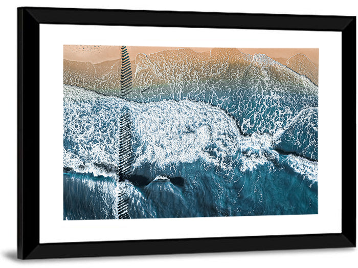Aerial Pier Pilings Over Surf Wall Art as a framed print