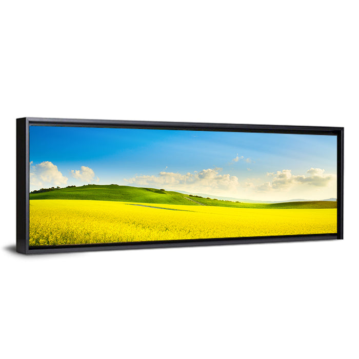 Rapeseed Field and Rolling Hills Under Blue Sky Wall Art as a framed canvas
