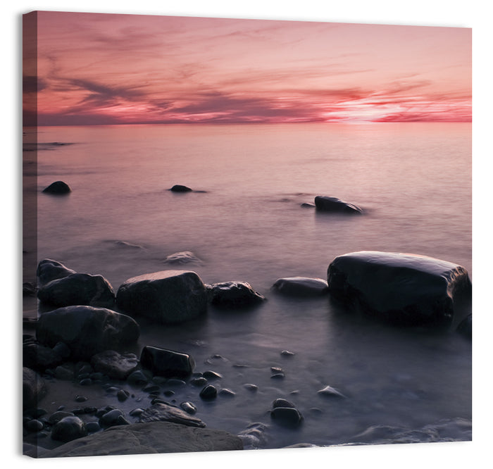 Pink Dusk Lakeshore with Silhouetted Rocks Wall Art as a canvas print