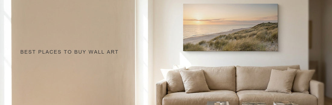 Best places to buy wall art: a bright living room with a long linen sofa and a wide coastal dunes canvas at golden hour on the wall