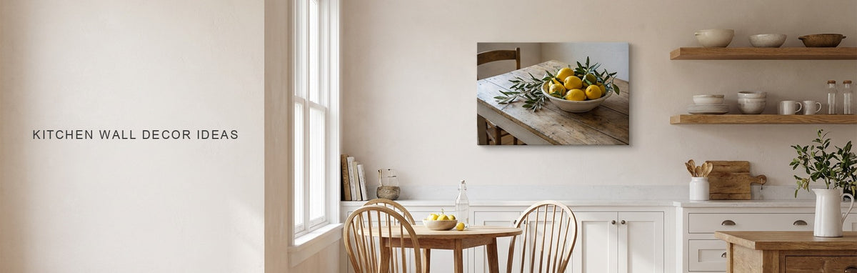 Kitchen wall decor ideas: a bright farmhouse kitchen with white cabinets and an oak shelf and a lemons and olive branches still life canvas on the wall