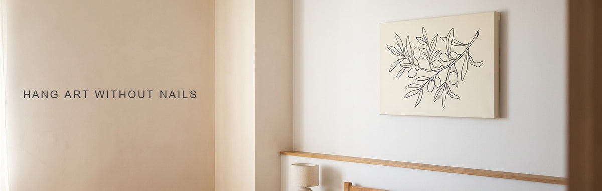 How to hang pictures without nails: a minimalist botanical line study on a plain white bedroom wall above a picture ledge