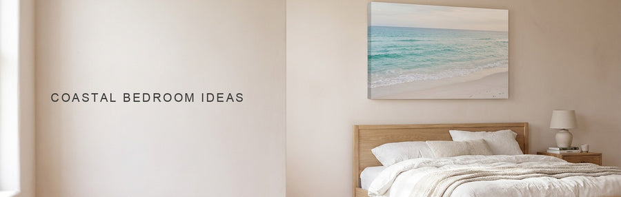 Coastal bedroom ideas in a white linen bedroom with a pale oak bed beneath a calm turquoise ocean and pale sand beach canvas
