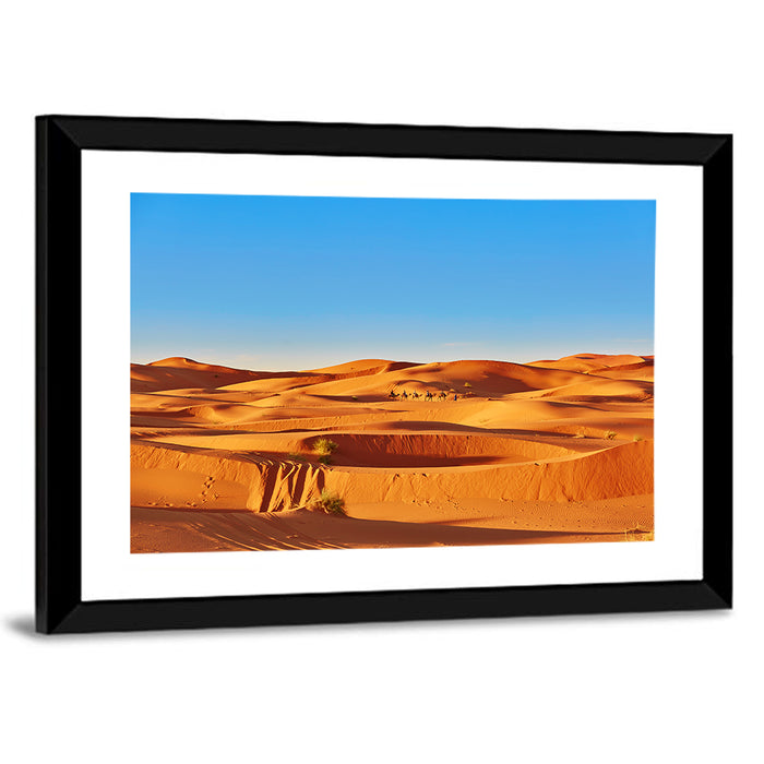 Sunlit Sahara Dunes with Camel Caravan Wall Art as a framed print