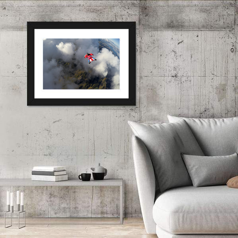 Red Wingsuit Skydiver Over Clouds Wall Art in a room, landscape