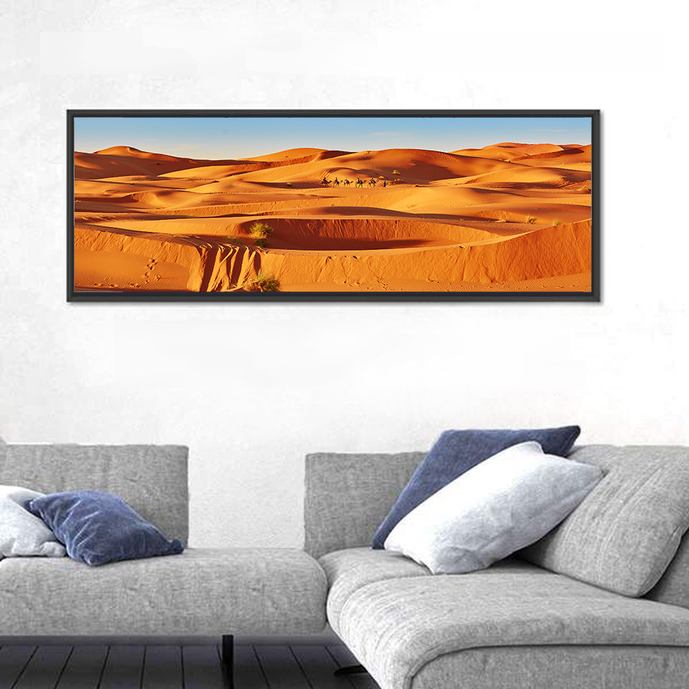 Sunlit Sahara Dunes with Camel Caravan Wall Art in a room, panoramic