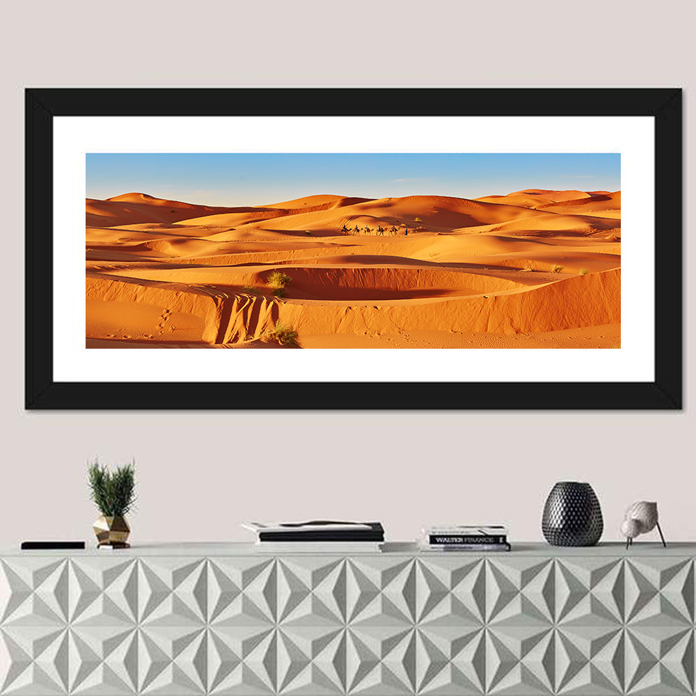 Sunlit Sahara Dunes with Camel Caravan Wall Art in a room, panoramic