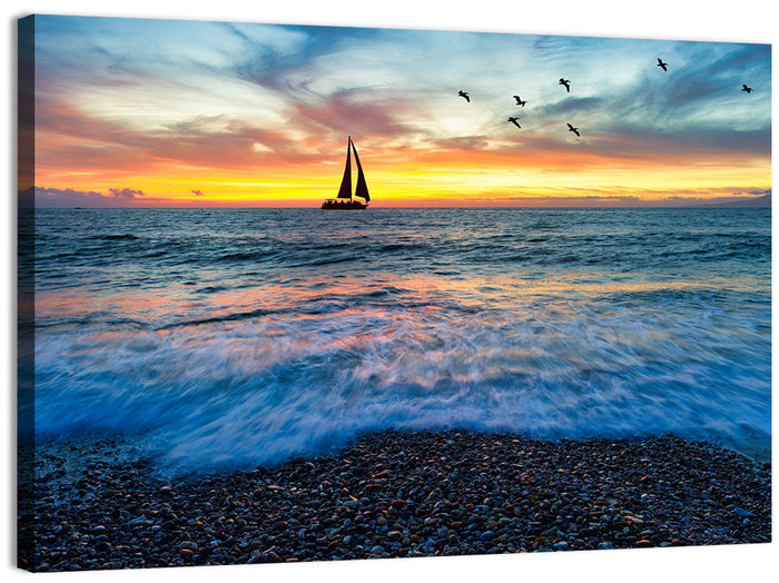 Sunset Sailboat Over Pebble Shore Wall Art as a canvas print