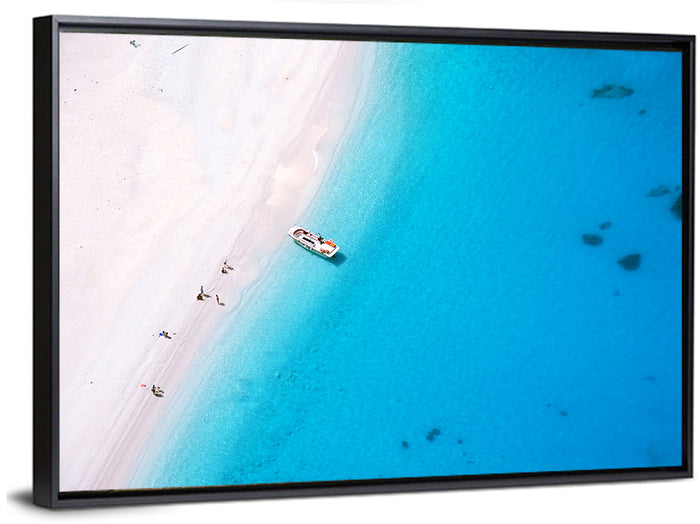 Aerial Beach Bay with White Boat Wall Art as a framed canvas