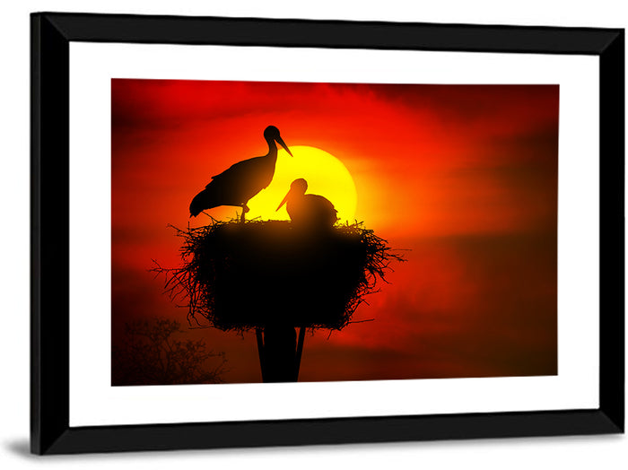 Storks in Nest at Sunset Wall Art as a framed print