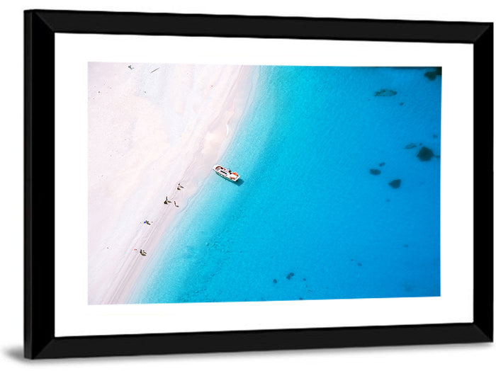 Aerial Beach Bay with White Boat Wall Art as a framed print