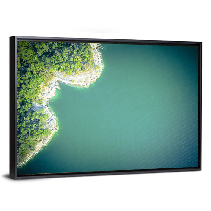 L-shaped Coastline Over Teal Lake Wall Art as a framed canvas