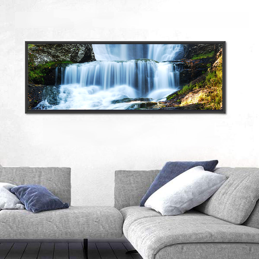 White Waterfall Over Mossy Rocks Wall Art in a room, panoramic