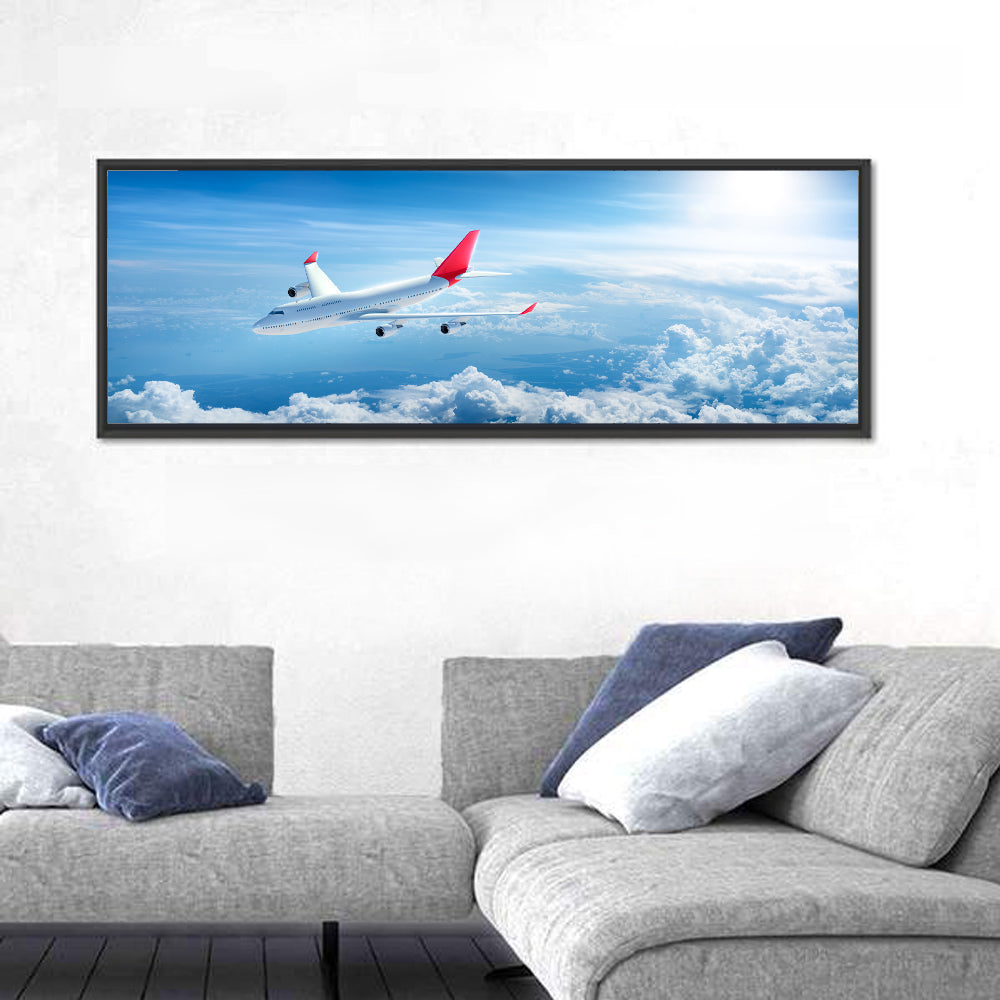 Airplane Over Blue Cloudscape Wall Art in a room, panoramic