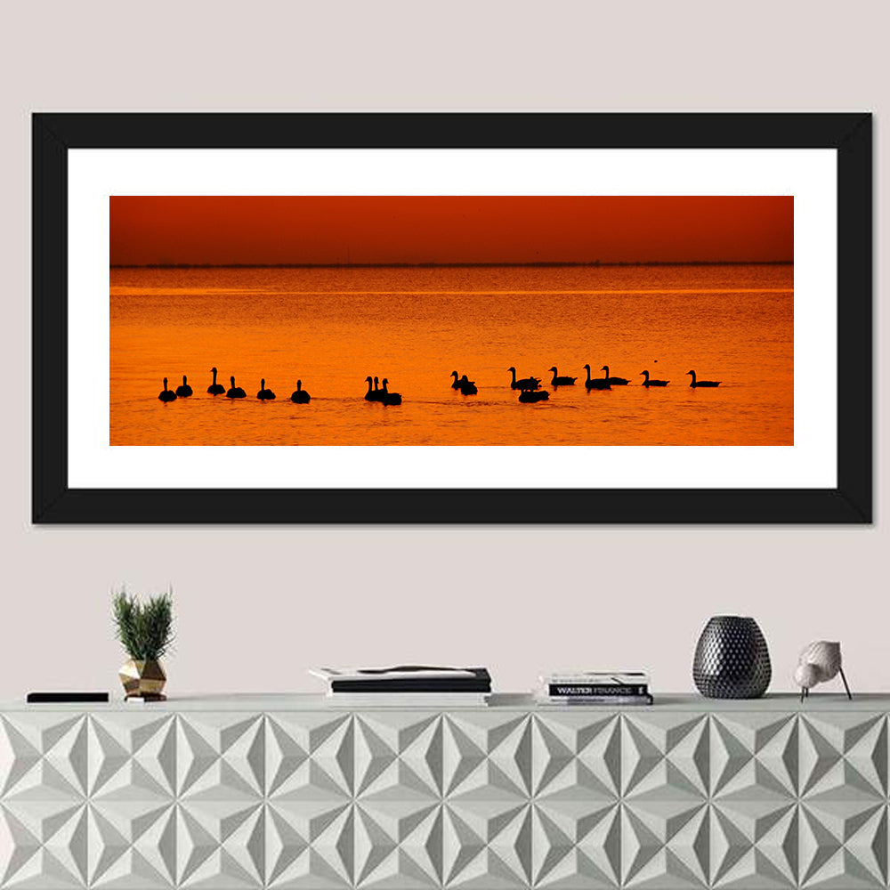 Geese Silhouettes at Orange Sunset Wall Art in a room, panoramic