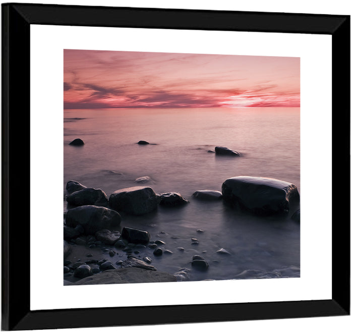 Pink Dusk Lakeshore with Silhouetted Rocks Wall Art as a framed print
